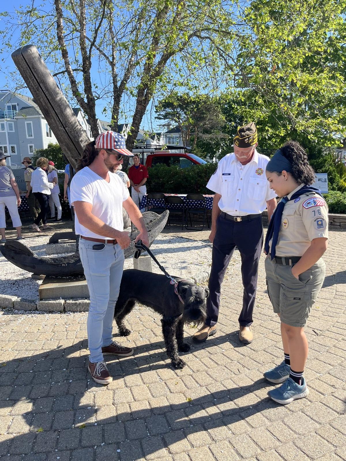 Thaler Hefel speaking with veterans and a Scout at a community event